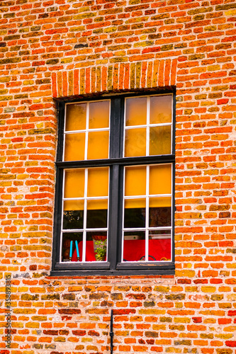 It's Medieval houses with flowers at the windows in the Historic Centre of Bruges, Belgium. part of the UNESCO World Heritage site