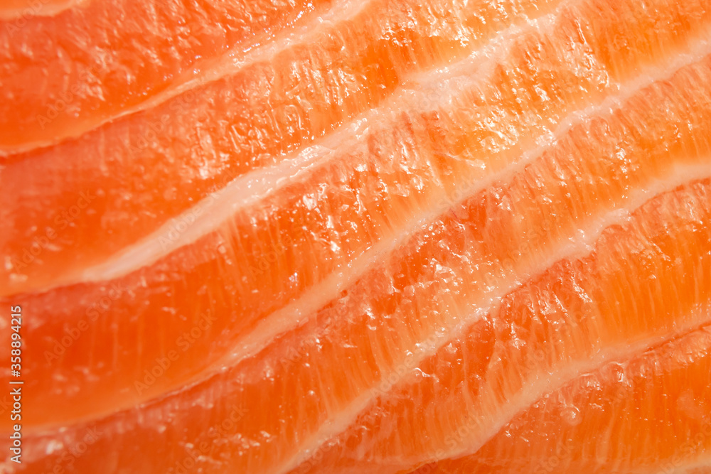 Foods rich in protein and selenium, expensive seafood and lean meat concept with full frame macro close up picture of a fresh pink with white stripes salmon slice
