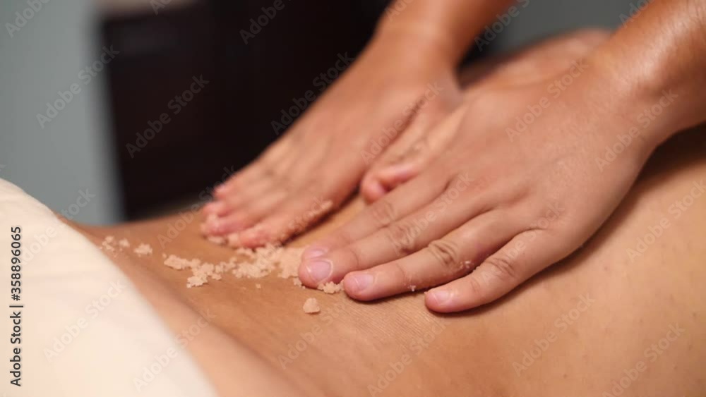 Slow motion video of a masseur giving a body scrub treatment Slow motion video of a masseur giving a body scrub treatment