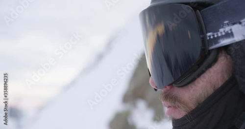 closeup skier with reflecting skiing goggles on a mountain at dawn with shallow depth of field photo