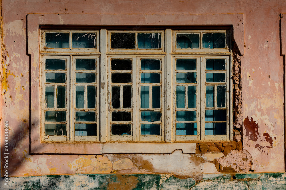 Broken window in the ghost town of Bolama, the former capital of Portuguese Guinea Broken window in the ghost town of Bolama, the former capital of Portuguese Guinea