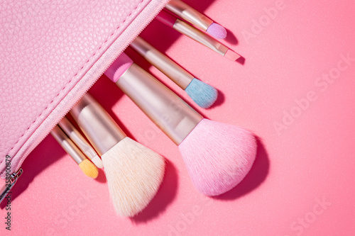 Make up brushes with powder on pink background