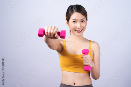 Asian sporty woman with dumbbell fit slim body isolated on white background. concept of healthy lifestyle.