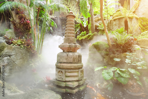 Beautiful Chinese stone pagoda in a waterfall in the garden photo