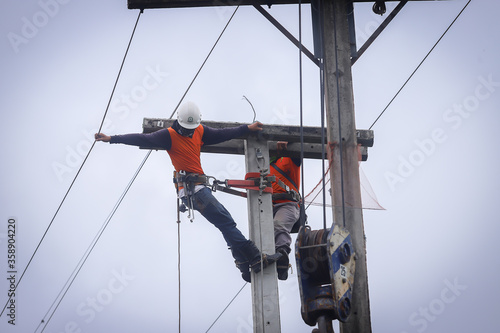 Electricians operate the electrical transmission system on the electricity pole.