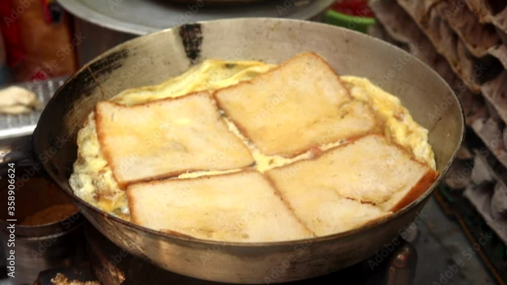 Indian style egg pizza omelette topped with cheese, sauces, garnish and vegetables made on hot oil pan in butter with high flames. Indian style egg pizza omelette topped with cheese, sauces, garnish and vegetables made on hot oil pan in butter with high flames.