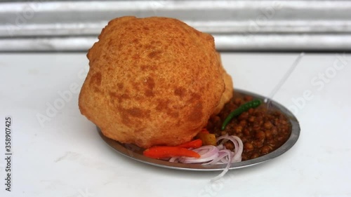 Making choley for cholle bhature serving with onions, red indian salad and peas. photo