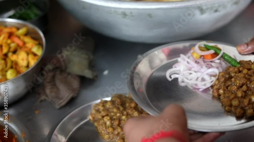 Making choley for cholle bhature serving with onions, red indian salad and peas. photo