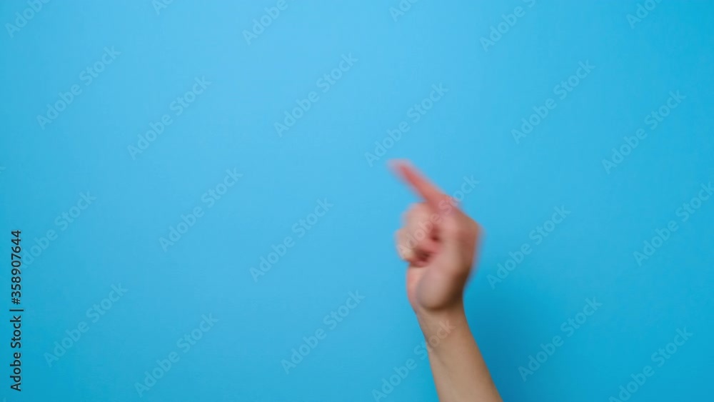 Hand gesture. Close up of female finger pointing at copy space, isolated on blue studio background with copy space for advertisement. Advertising area, mockup. Hand gesture. Close up of female finger pointing at copy space, isolated on blue studio background with copy space for advertisement. Advertising area, mockup.
