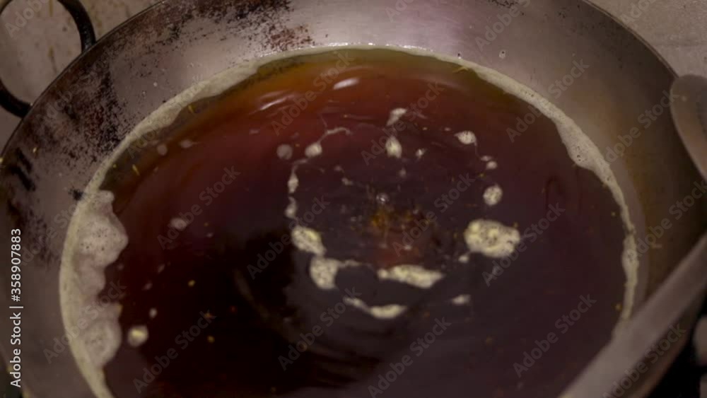 Making fried potato balls or indian vada in a kadhai filled with oil. Vada pav. Making fried potato balls or indian vada in a kadhai filled with oil. Vada pav.