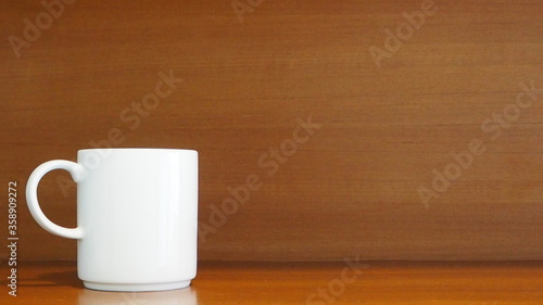 White porcelain mug on wooden shelf in the kitchen room at home Living and lifestyle concept