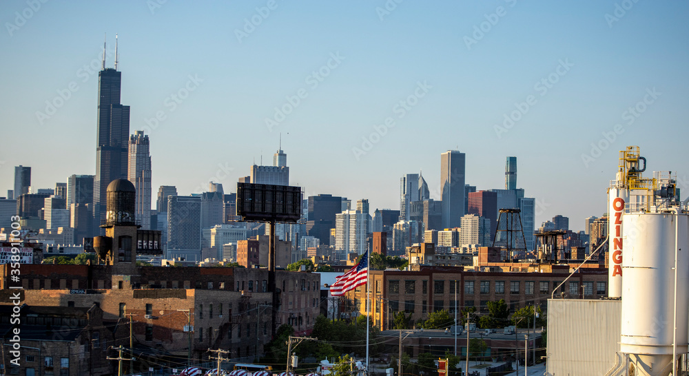 Fototapeta premium Chicago Skyline view of beautiful architecture of the city's wonderful downtown urban district. The cityscape buildings have a warm glows from the sun setting golden hour