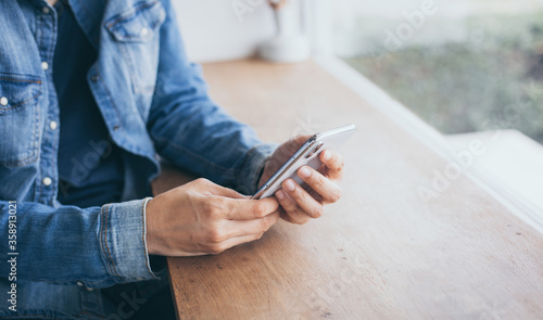 using cell phone.hand holding texting message on screen mobile chatting,search internet information sitting in office.technology device contact communication connecting people concept