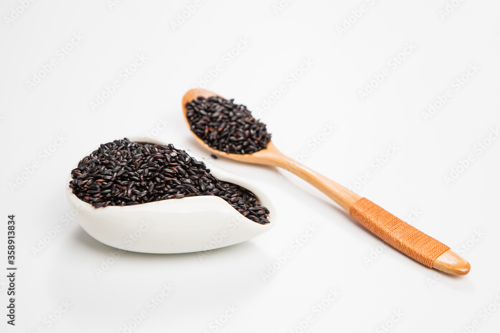 Black wild rice in a wooden spoon Black wild rice in a wooden spoon