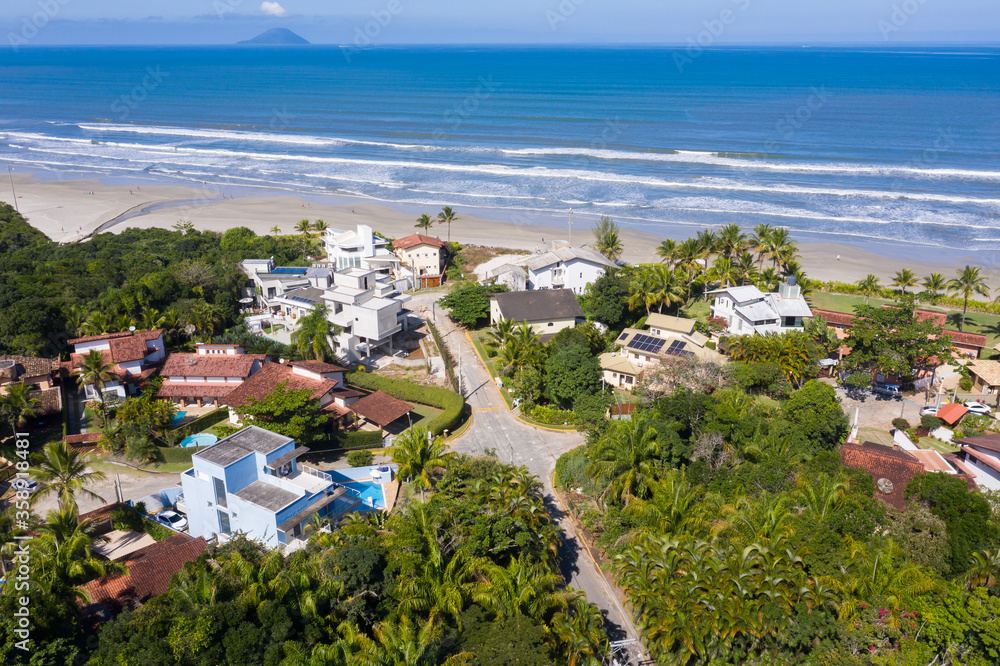 vista aérea da praia de guaratuba incluindo suas casas e a estrada paralela ao mar