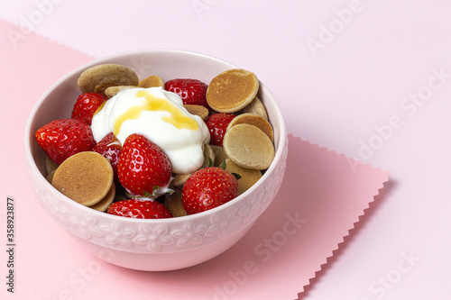 Homemade cereals mini pancake with yogurt, honey and strawberries on colorful background. photo