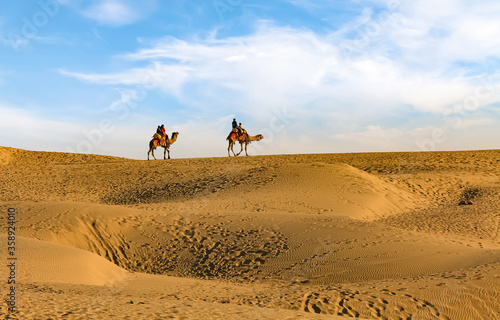 Thar desert sand dunes with view of tourist enjoying camel safari at Jaisalmer Rajasthan India