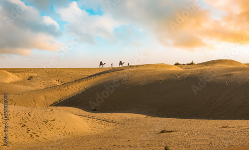 Sand dunes of Thar desert Jaisalmer with view of tourist enjoying camel safari at Rajasthan India