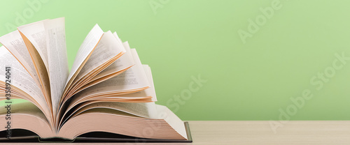 Photos The book is open, lying on the table, sheets fanned out on a green background
