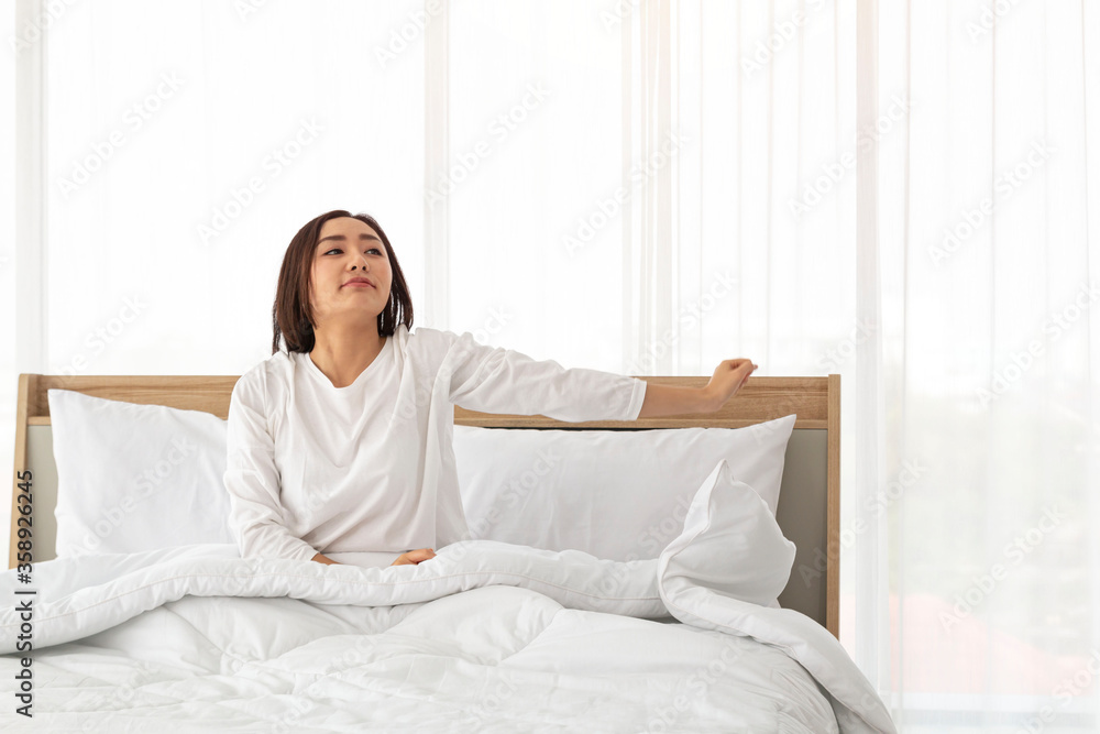 Young girl stretching in bed after wake up. Portrait of beautiful asian woman enjoying fresh soft bed linen mattress in bedroom. Woman Stretching in Her Bed. A Girl waking up in the Morning on bed. Young girl stretching in bed after wake up. Portrait of beautiful asian woman enjoying fresh soft bed linen mattress in bedroom. Woman Stretching in Her Bed. A Girl waking up in the Morning on bed.