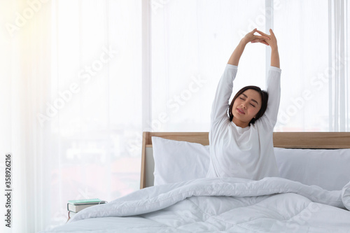 Wallpaper Mural Portrait of young beautiful asian girl relax in white bedroom. Young Asian women in bed and waking up in the morning. Girl wakeup early morning feeling lazy and stretching her body on bed. Torontodigital.ca