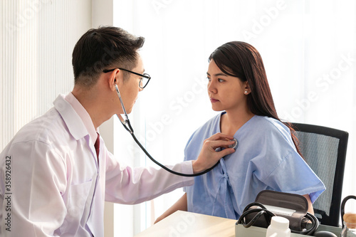 Female Patient Being Reassured by Doctor. Young patient visiting doctor in hospital. Smiling patient receiving a medical consultation and looking at camera. healthcare and assistance concept.