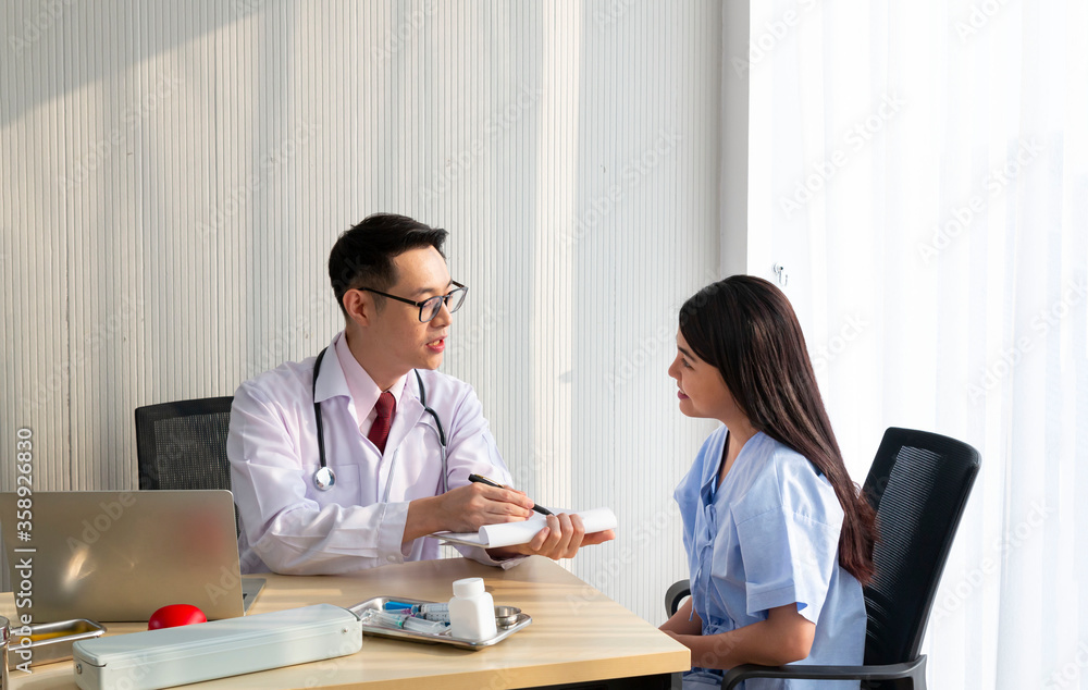 Doctor with female patient. Doctor and patient discussing something while sitting at the table, explaining diagnosis to his female patient. Medicine and healthcare concept. Coronavirus, Covid-19. Doctor with female patient. Doctor and patient discussing something while sitting at the table, explaining diagnosis to his female patient. Medicine and healthcare concept. Coronavirus, Covid-19.