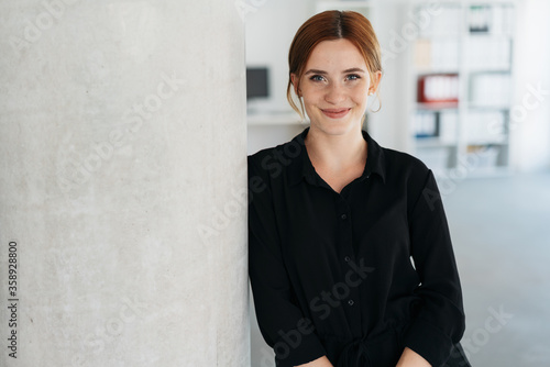 Friendly young businesswoman smiling at camera photo