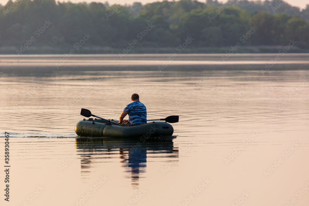 A man floats in a boat on the lake