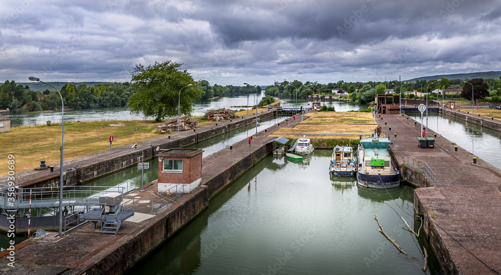 Fototapeta premium Large view by wide angle on Seine River in France, with canal boats on the river, parked.