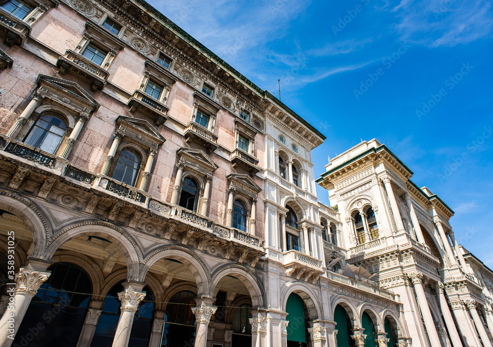 Facade of Galleria Vittorio Emanuele II and Old Beautiful Building on Duomo Square (Piazza del Duomo) in Milan.