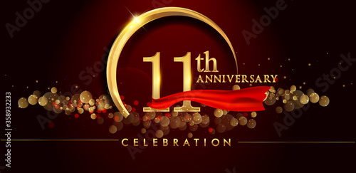 11th anniversary logo with golden ring, confetti and red ribbon isolated on elegant black background, sparkle, vector design for greeting card and invitation card photo