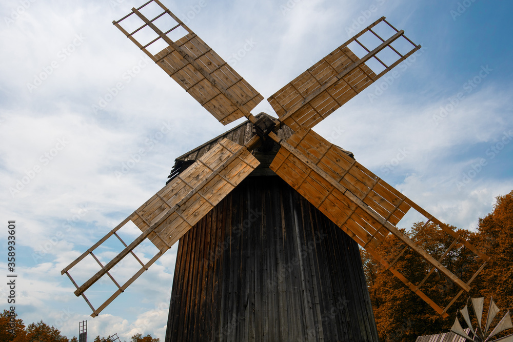 wooden windmill on the green plain on a beautiful summer day