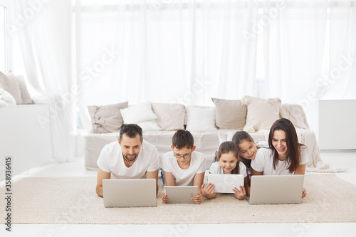 Large family with gadgets. Children and parents at home with a laptop. 
