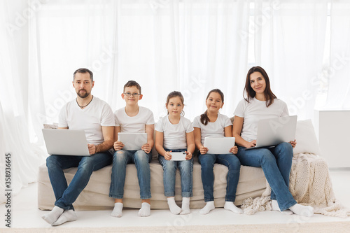 Large family with gadgets. Children and parents at home with a laptop. 