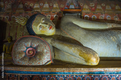 Fragment of a sculpture of the reclining Buddha in the interior of the ancient Buddhist cave temple Rangiri Dambulu Raja Maha Viharaya. Dambulla, Sri Lanka photo