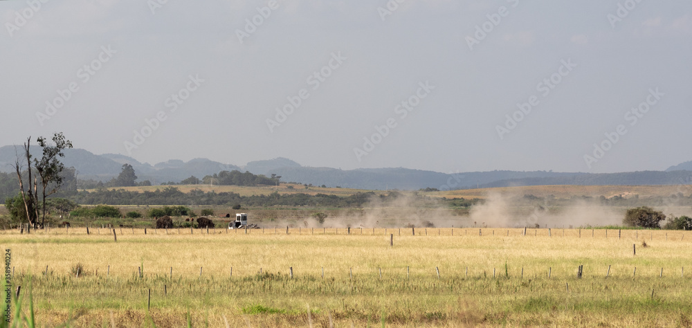 Dirt road cutting through the rural landscape in an agricultural production field Dirt road cutting through the rural landscape in an agricultural production field