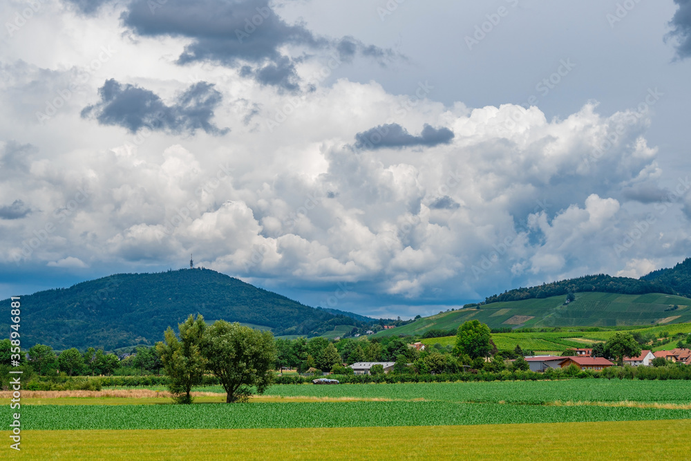 The green Black Forest mountains viewed from the valley in Bühl, Germany, on a summer day with some rainy clouds The green Black Forest mountains viewed from the valley in Bühl, Germany, on a summer day with some rainy clouds