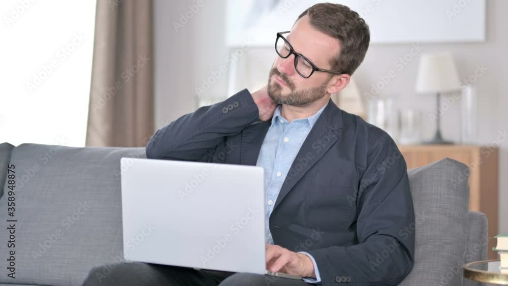 Young Businessman with Laptop having Neck Pain at Home Young Businessman with Laptop having Neck Pain at Home