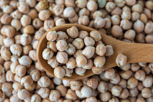 Close-up  view of chickpeas in a wooden spoon.