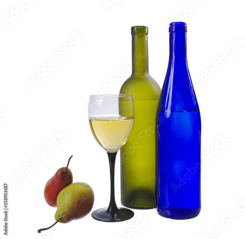 Two bottles, a glass of wine and pears on a white background.