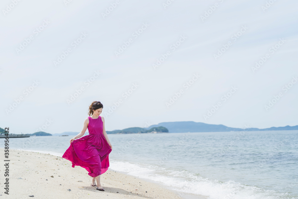 リゾート地の海でワンピースを着た女性