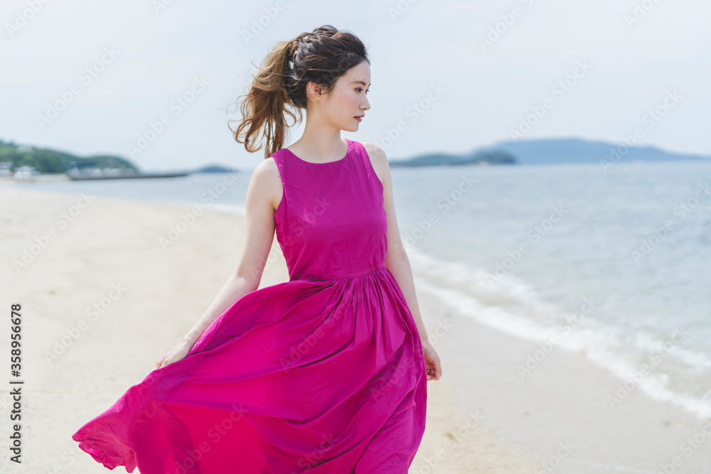 リゾート地の海でワンピースを着た女性