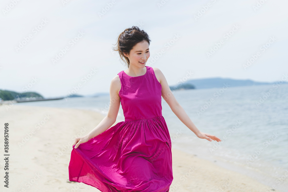 リゾートで海沿いを歩く女性