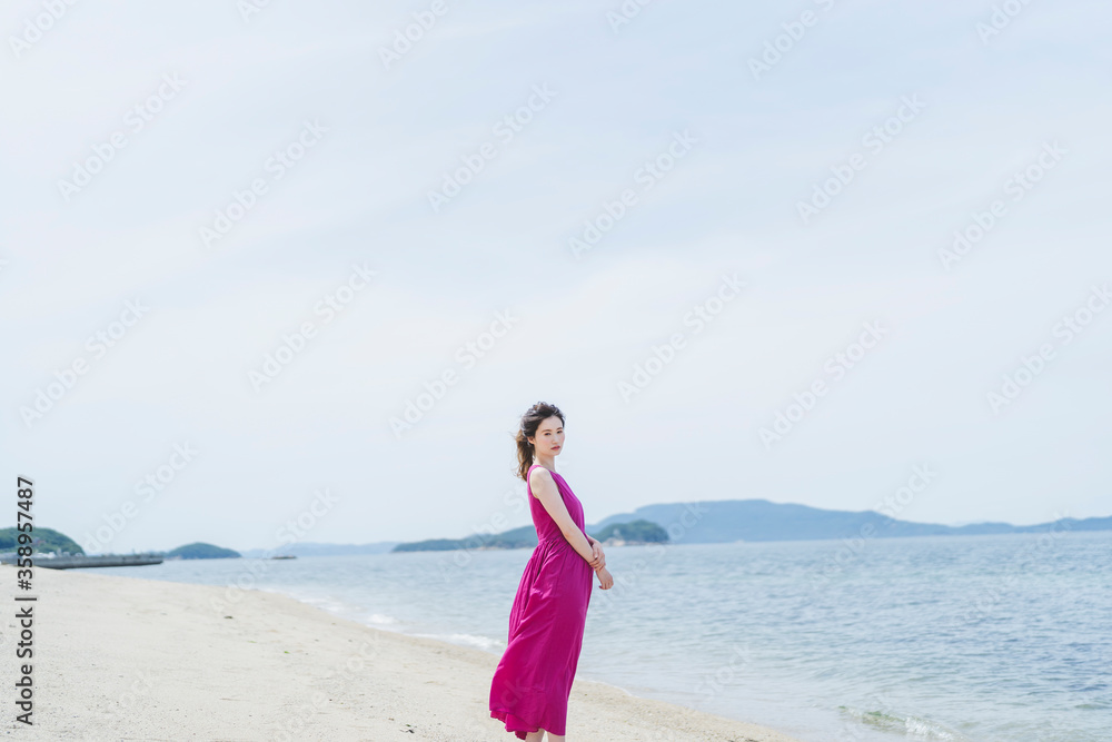 リゾートで海沿いを歩く女性