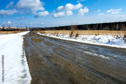 Fototapeta Naklejka Na Ścianę i Meble -  dirty road to the village meanders on the field