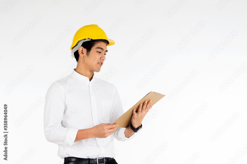 Portrait of handsome engineer wearing a yellow helmet at work and carrying a document on a white background Portrait of handsome engineer wearing a yellow helmet at work and carrying a document on a white background