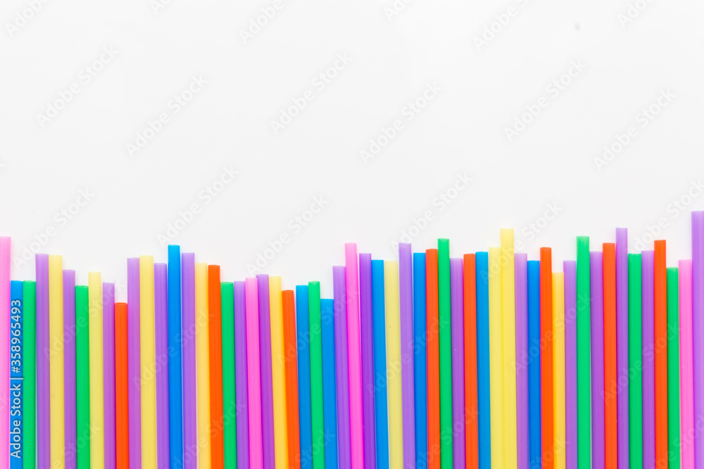 A strip of many plastic colored straws arranged in a row. Isolated A strip of many plastic colored straws arranged in a row. Isolated