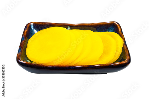 traditional korean and japanese Takuan (Danmuji) side dish from pickled daikon radish in ceramic bowl isolated on white background