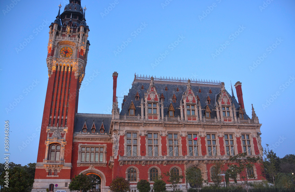 Calais, France, Europe, August 2019. Night view of the town hall building (Le Beffroi de l'Hôtel de Ville) and the bell tower of Calais. Flemish Renaissance style, world heritage